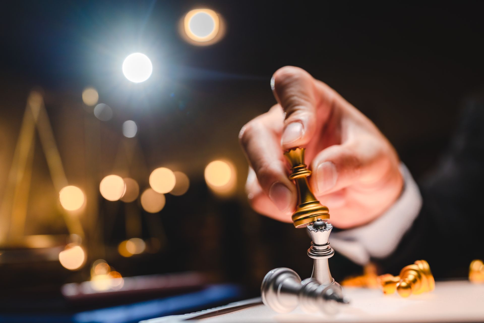 A person is holding a chess piece in their hand.