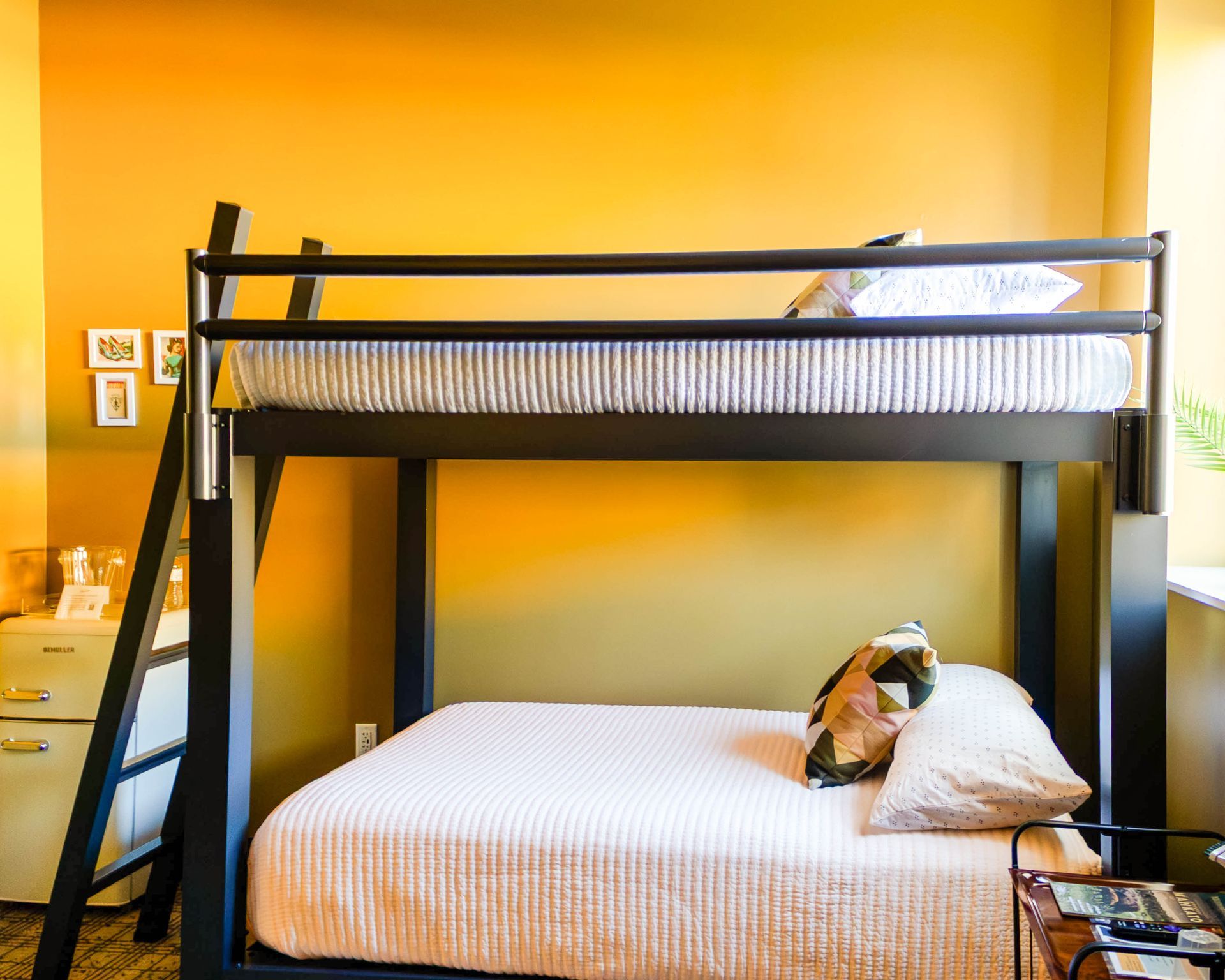 Bunk bed with white bedding and a stuffed animal in a yellow-walled room
