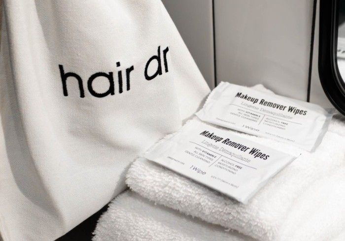 Hairdrip-branded towel beside two massage treatment cards on a spa chair