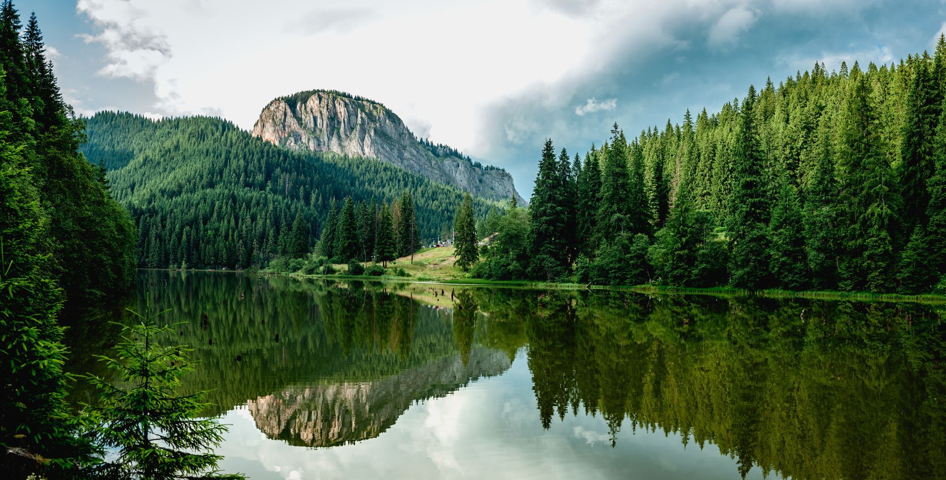 A lake surrounded by trees and mountains