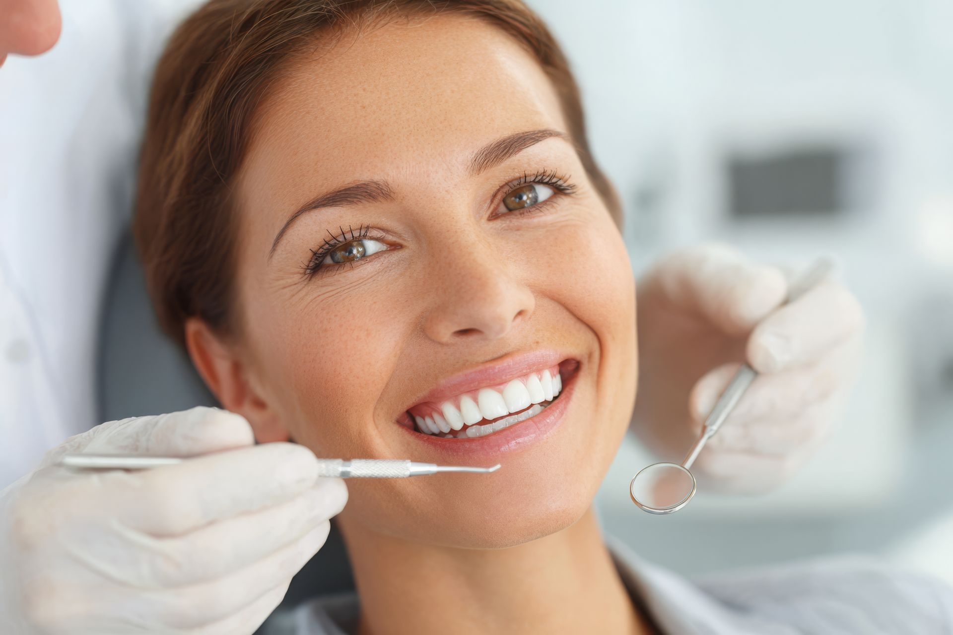 Happy patient receiving professional cosmetic dentistry treatment at a modern dental clinic. Happy patient receiving professional cosmetic dentistry treatment at a modern dental clinic.