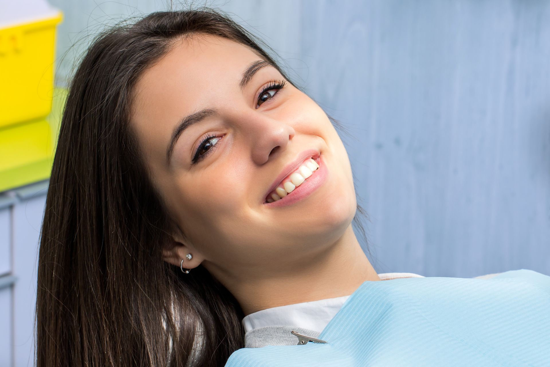 Woman reclining in dental chair during routine oral exam at modern clinic for treatment visit