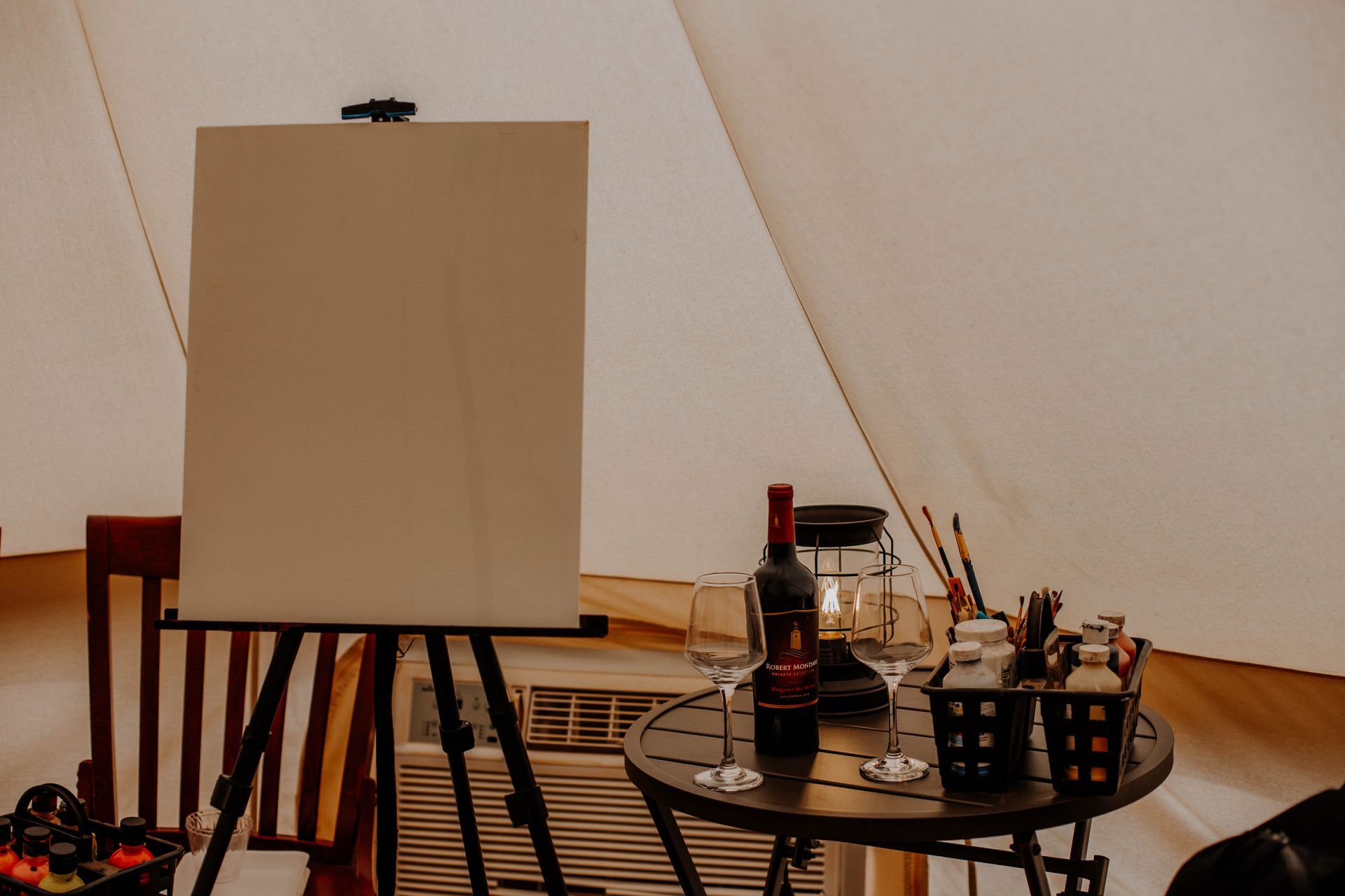 Cozy paint and wine setup inside a tent at Zion Glamping Adventures, offering guests a relaxing and creative evening activity