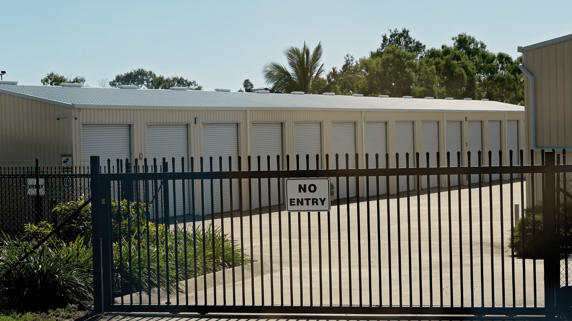 Storage units behind a black metal gate with a 