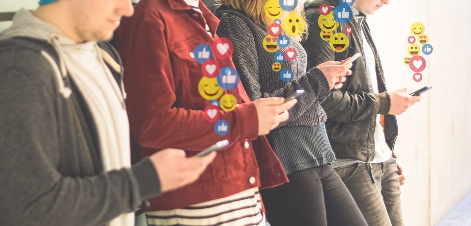 People on phones with emojis, like, heart, and smiley face icons floating above them.