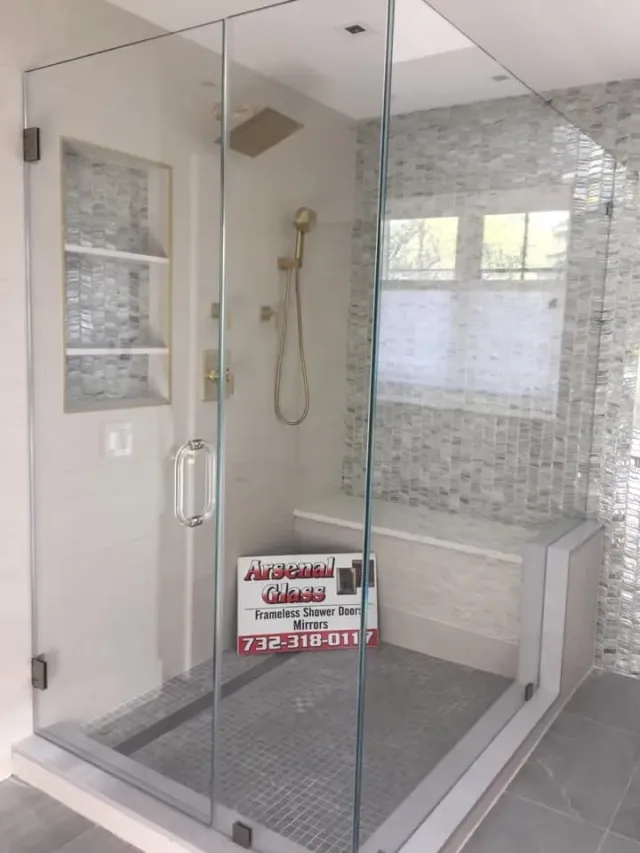 Custom frameless glass shower enclosure featuring a built-in bench and grey mosaic tile, installed by Arsenal Glass in NJ.