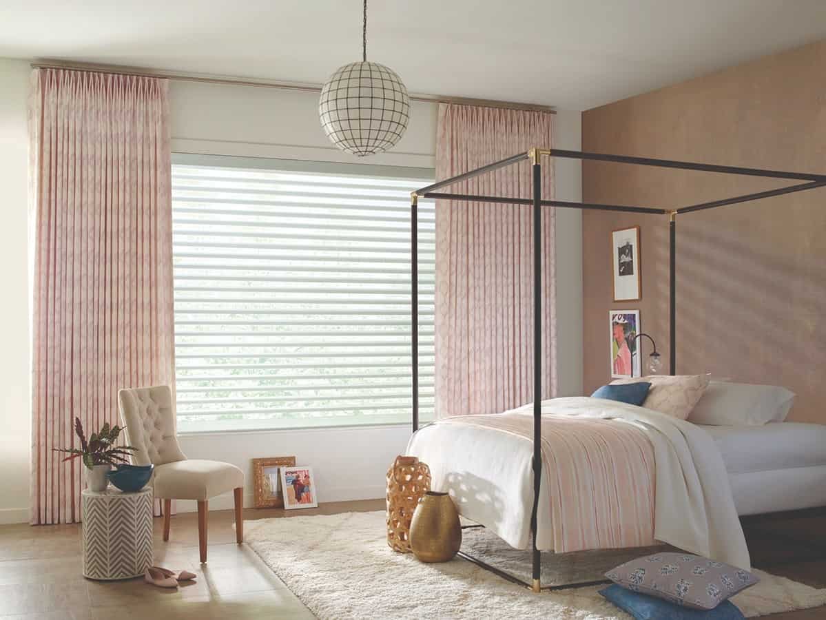 A neutral bedroom with drapery and sheer shades