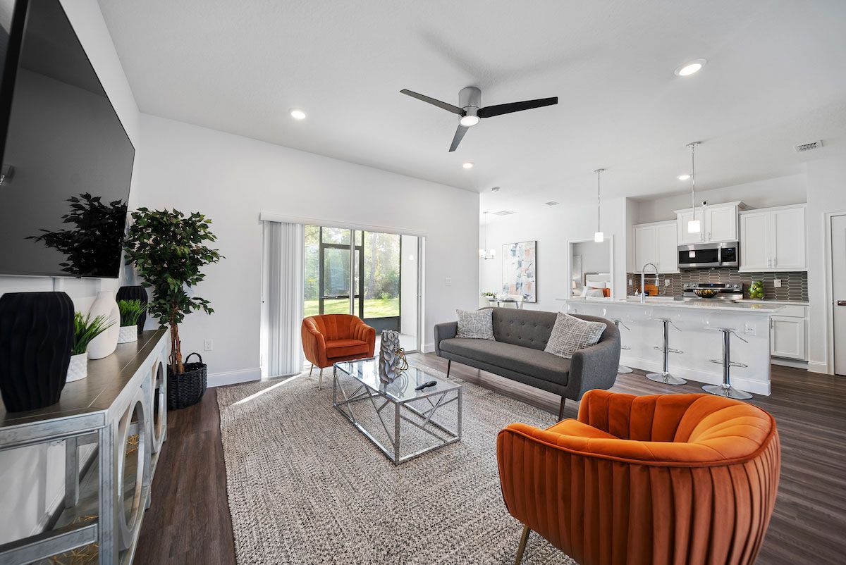 A living room with a couch , chairs , coffee table and television.