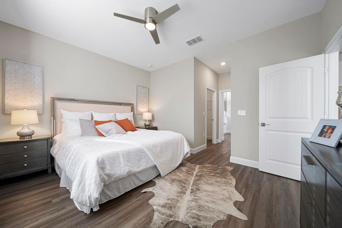 A bedroom with a king size bed and a ceiling fan.