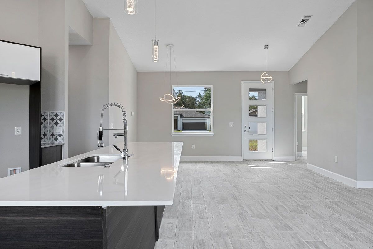 An empty kitchen with a sink and a window.