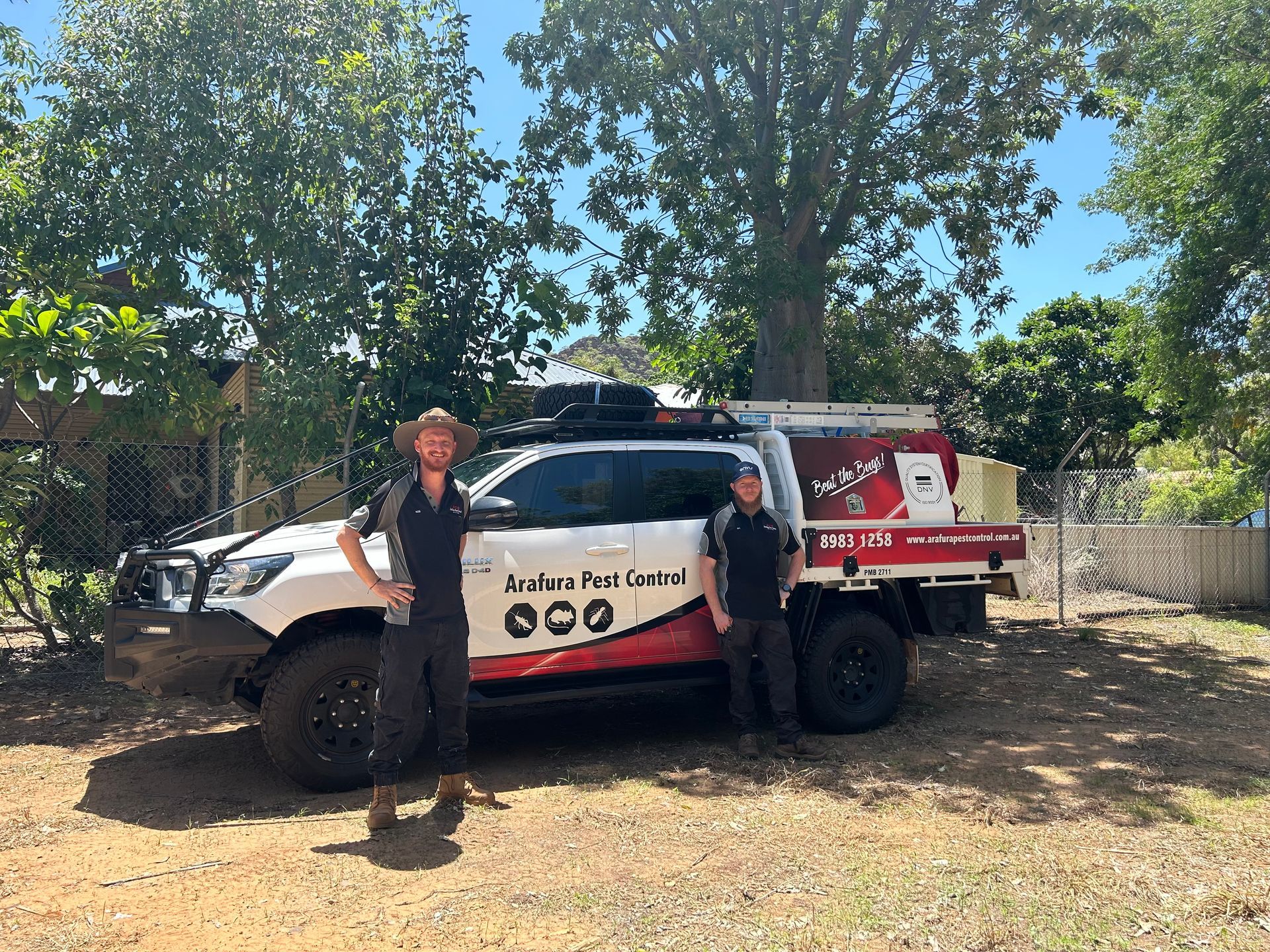 Two men are standing in front of a truck.