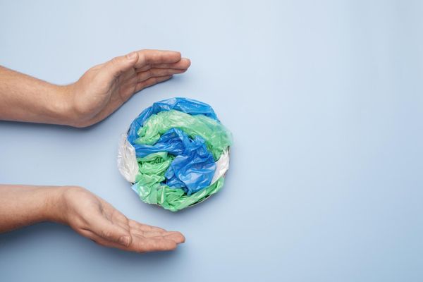 Una persona tiene in mano un globo fatto di sacchetti di plastica