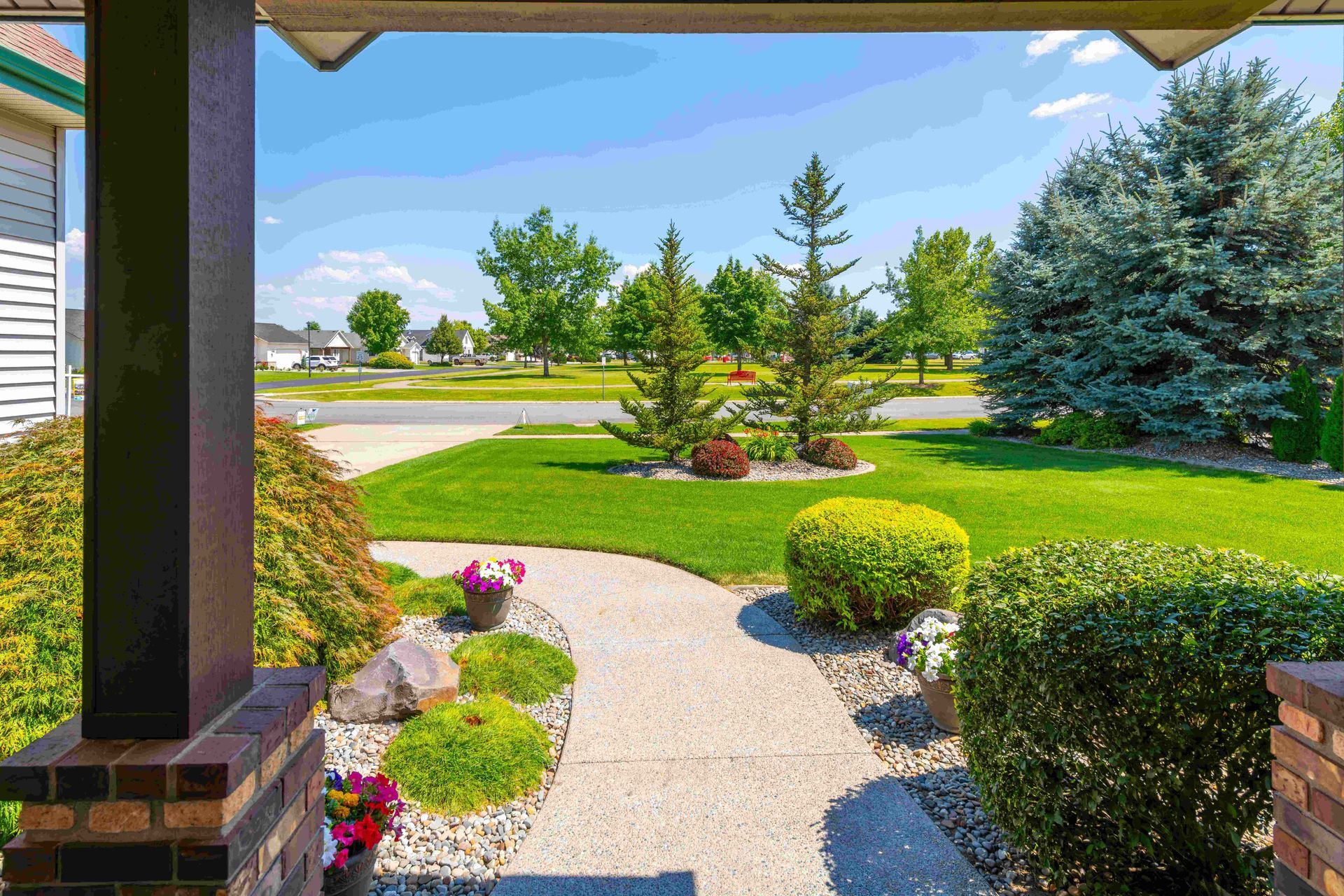 a view of a lush green lawn from the porch of a house