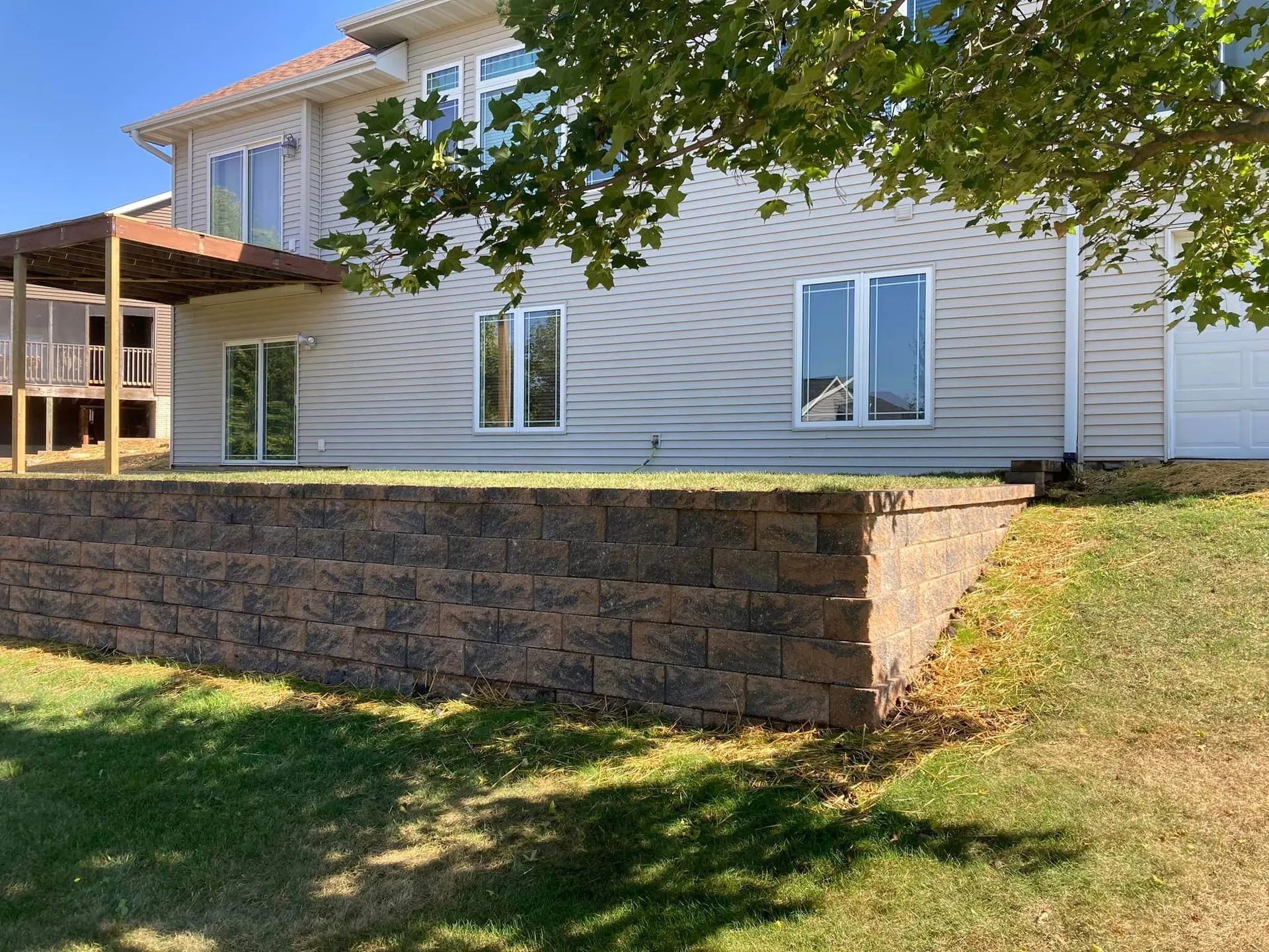 a large white house with a stone wall in front of it