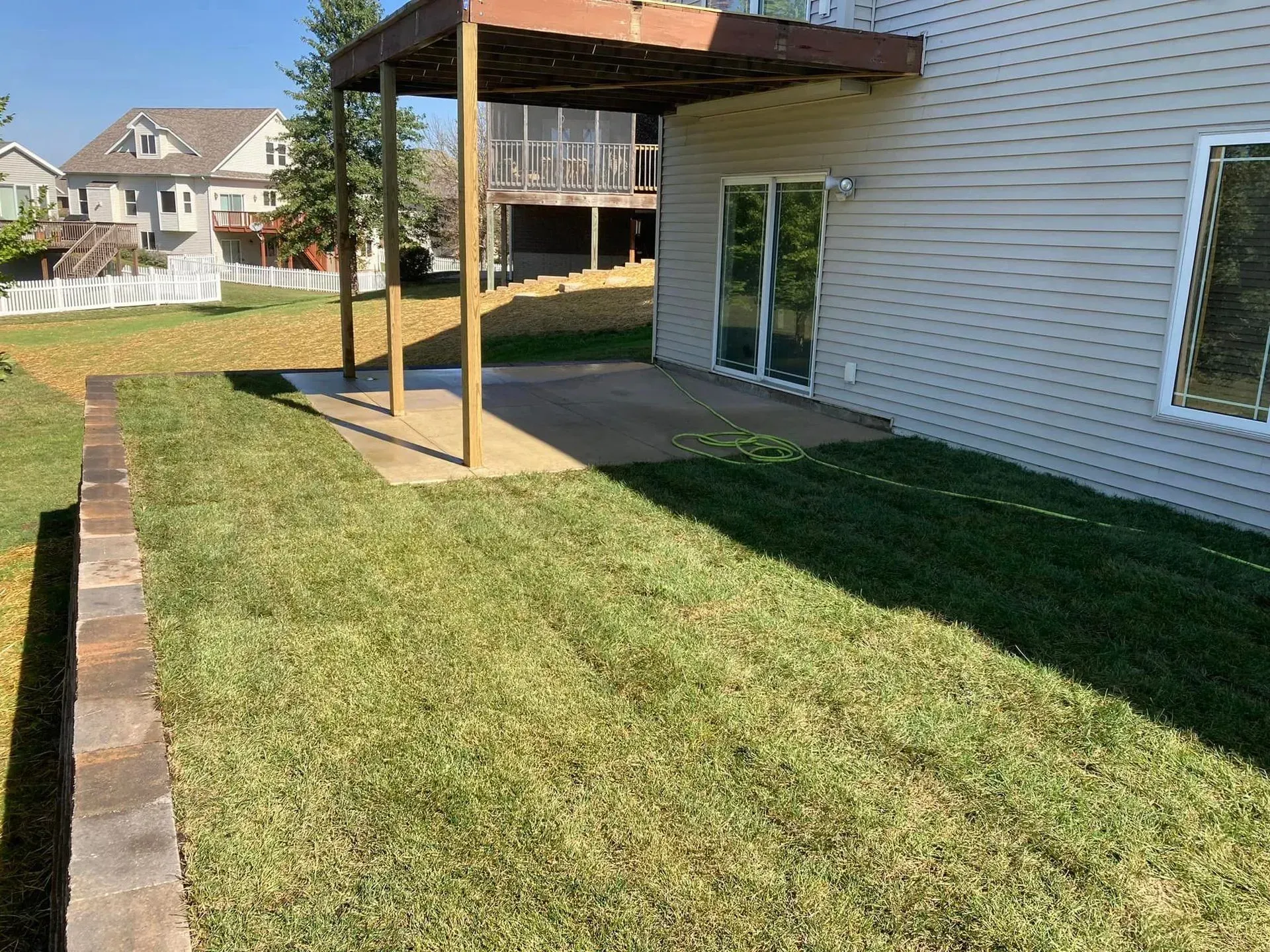 the backyard of a house with a large lawn and a deck