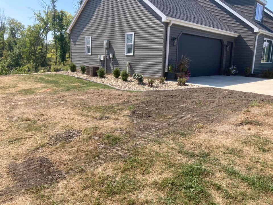 Gray house with a driveway and brown/dead grass in the yard.
