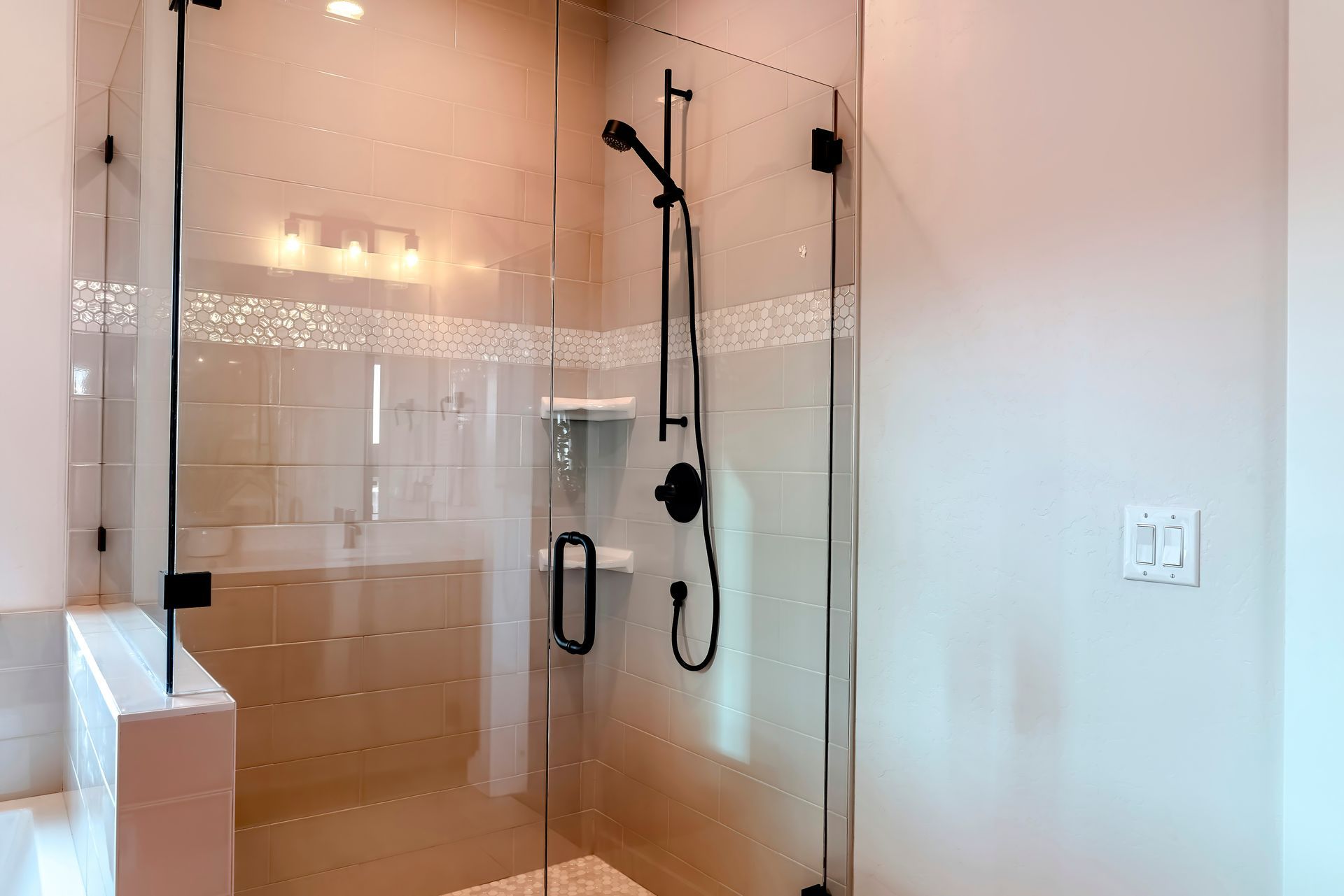Hinged shower door glass enclosure with black fixtures in modern bathroom. Hinged shower door glass enclosure with black fixtures in modern bathroom.