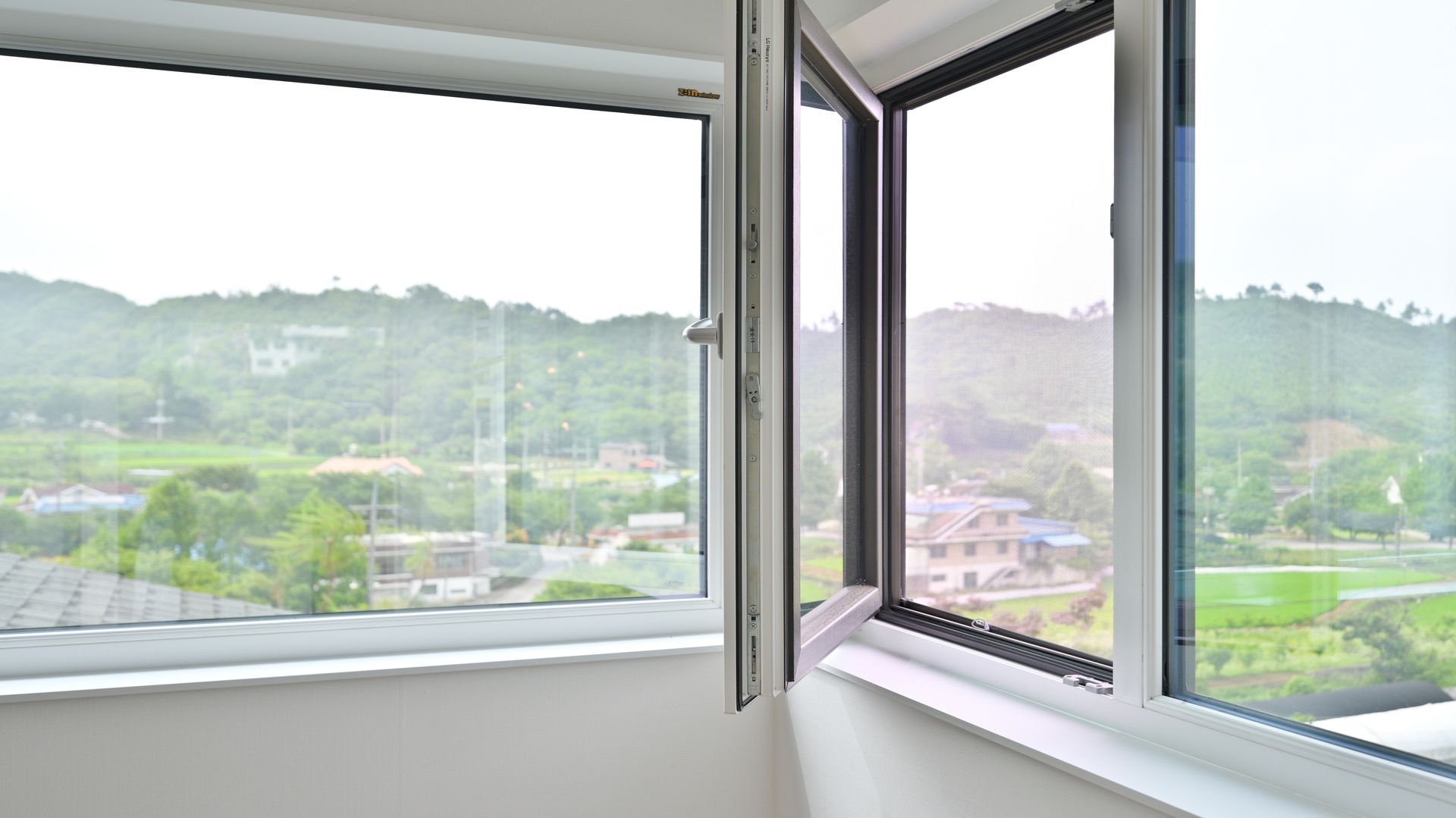 Open insulated window with double-pane glass overlooking a green landscape. Open insulated window with double-pane glass overlooking a green landscape.