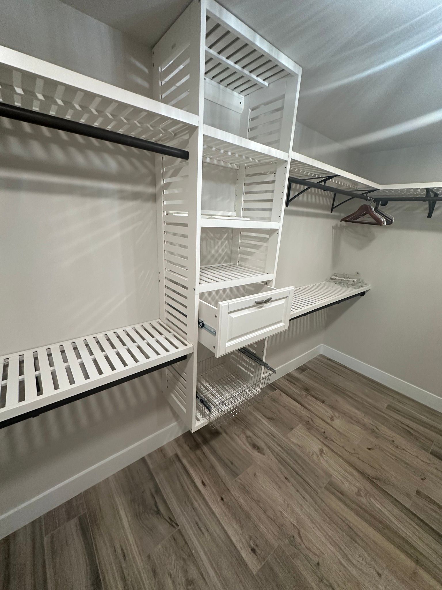 White closet shelving and storage with wooden flooring.