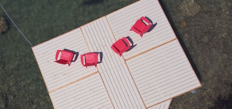 A group of red chairs are sitting on top of a wooden platform.