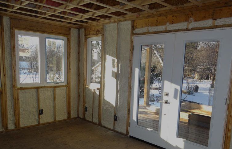 A room with a lot of windows and doors is being built.