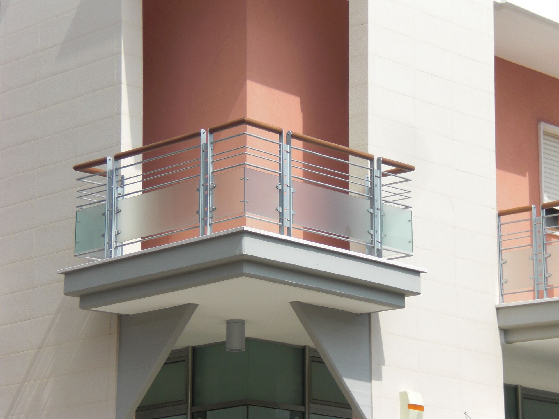Un balcone sul lato di un edificio con una ringhiera in vetro