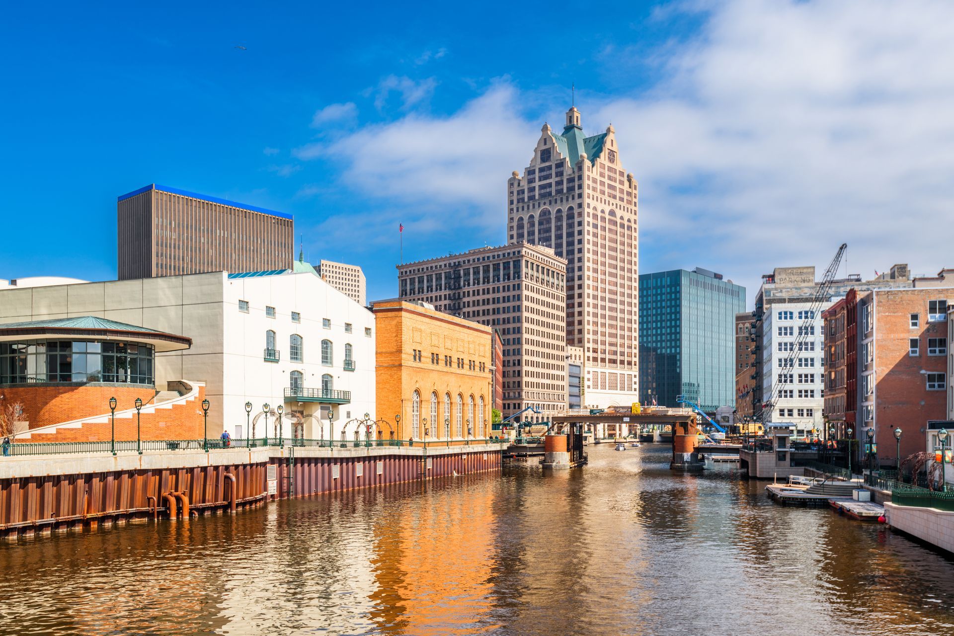 A city skyline with a river in the foreground and buildings in the background