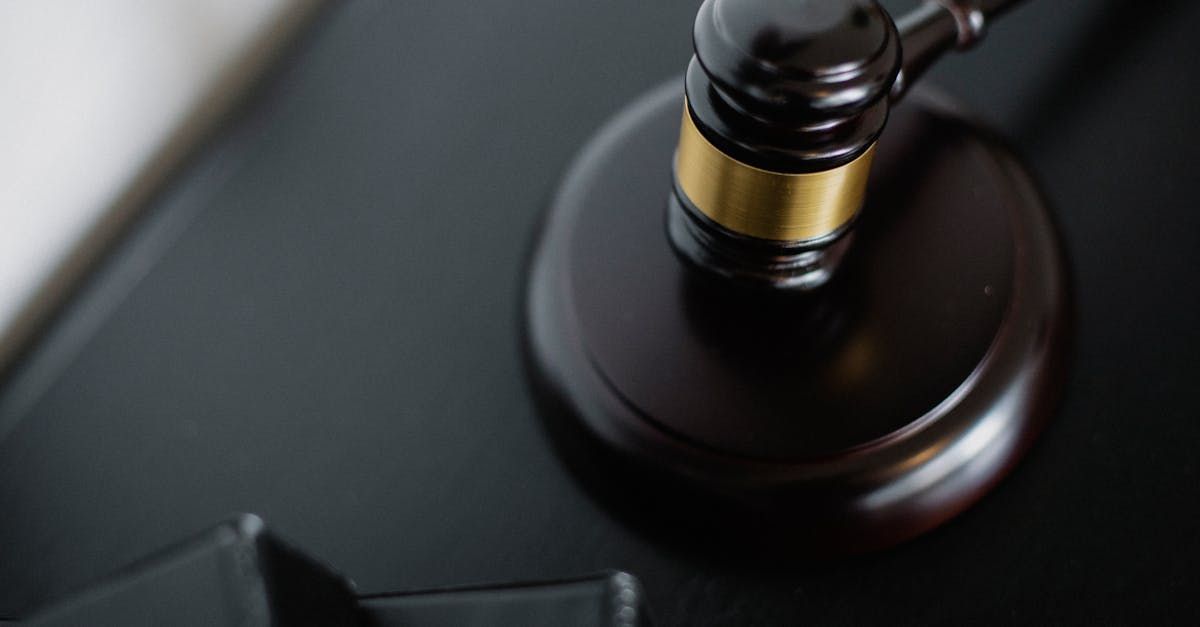 A wooden judge 's gavel is sitting on top of a black table.