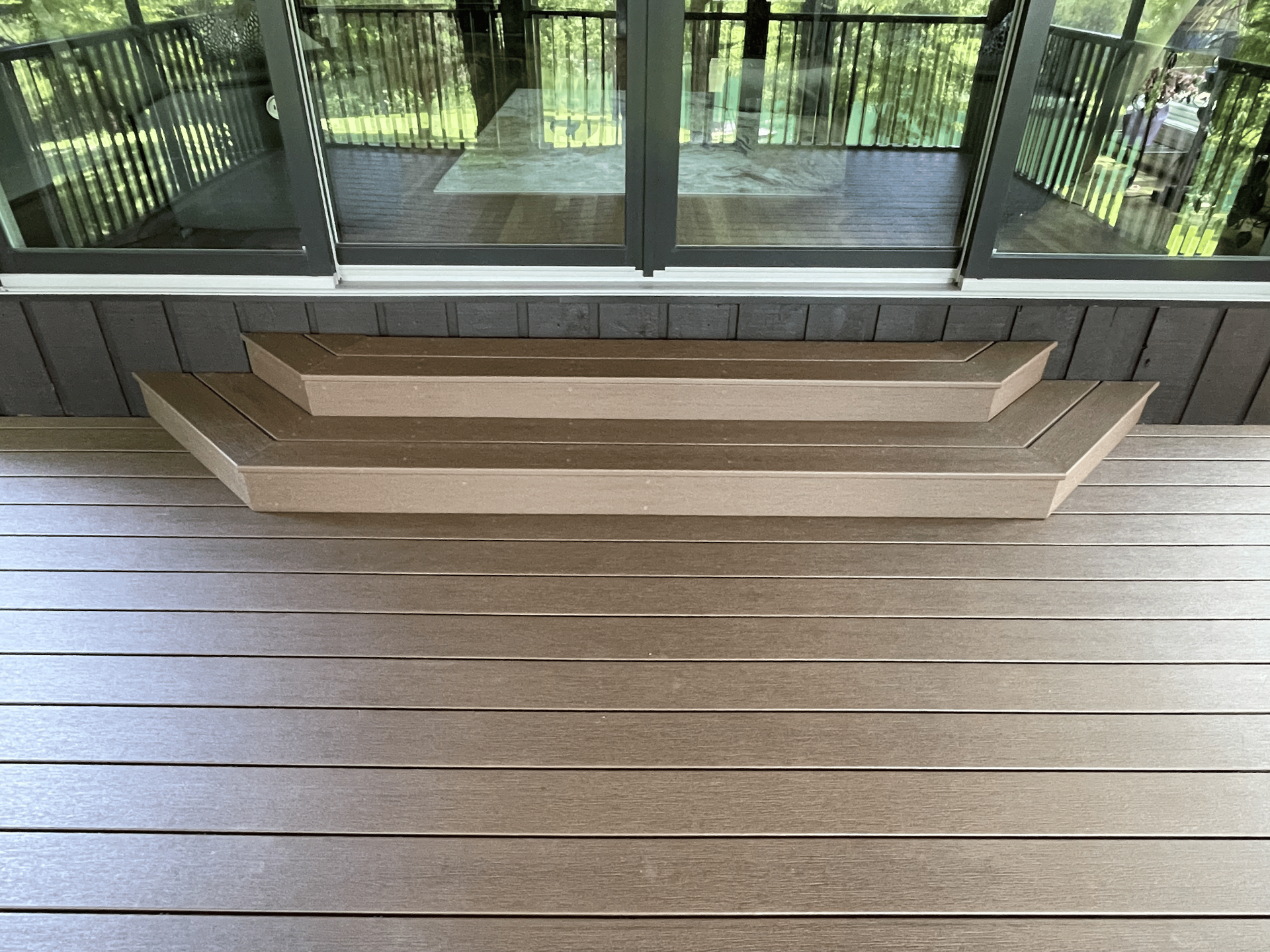 Custom deck construction with wood flooring and black metal railing in LaGrange