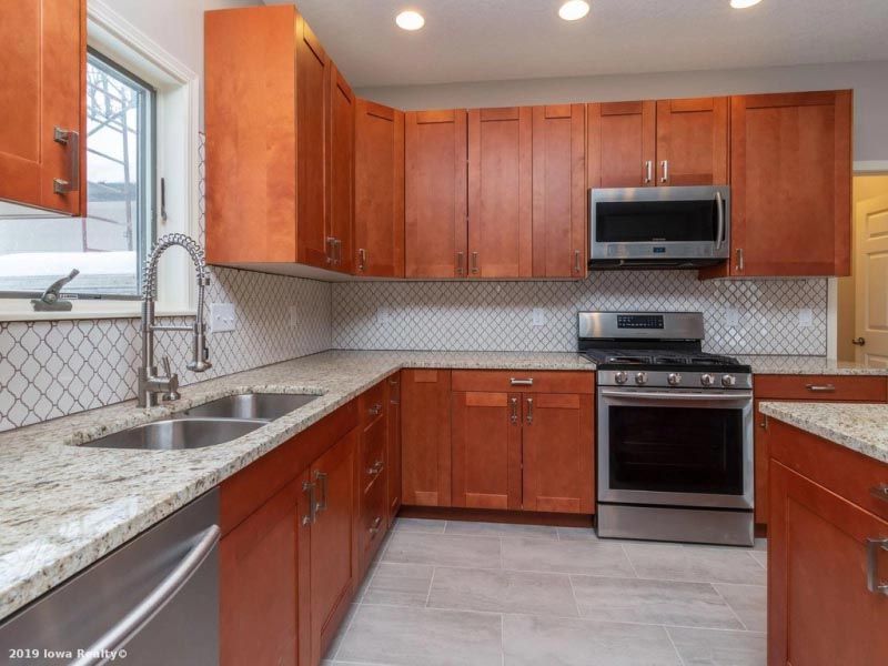 A kitchen with wooden cabinets stainless steel appliances and granite counter tops