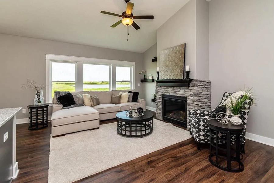 A living room with a fireplace and a ceiling fan.