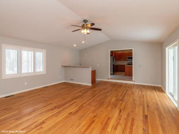 A living room with hardwood floors and a ceiling fan