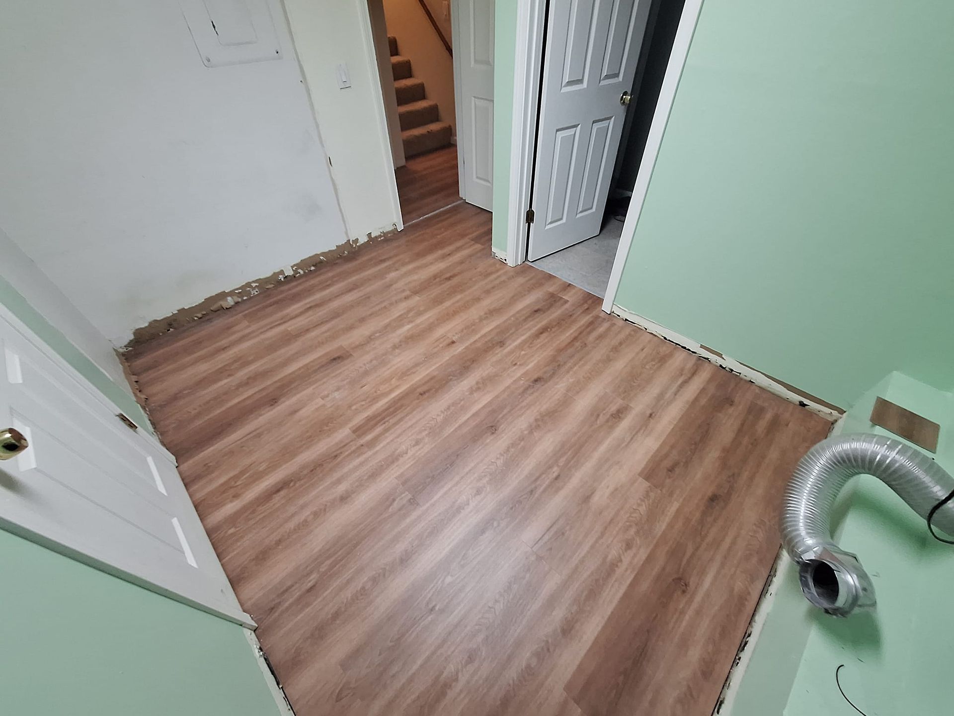 A room with a wooden floor and green walls.