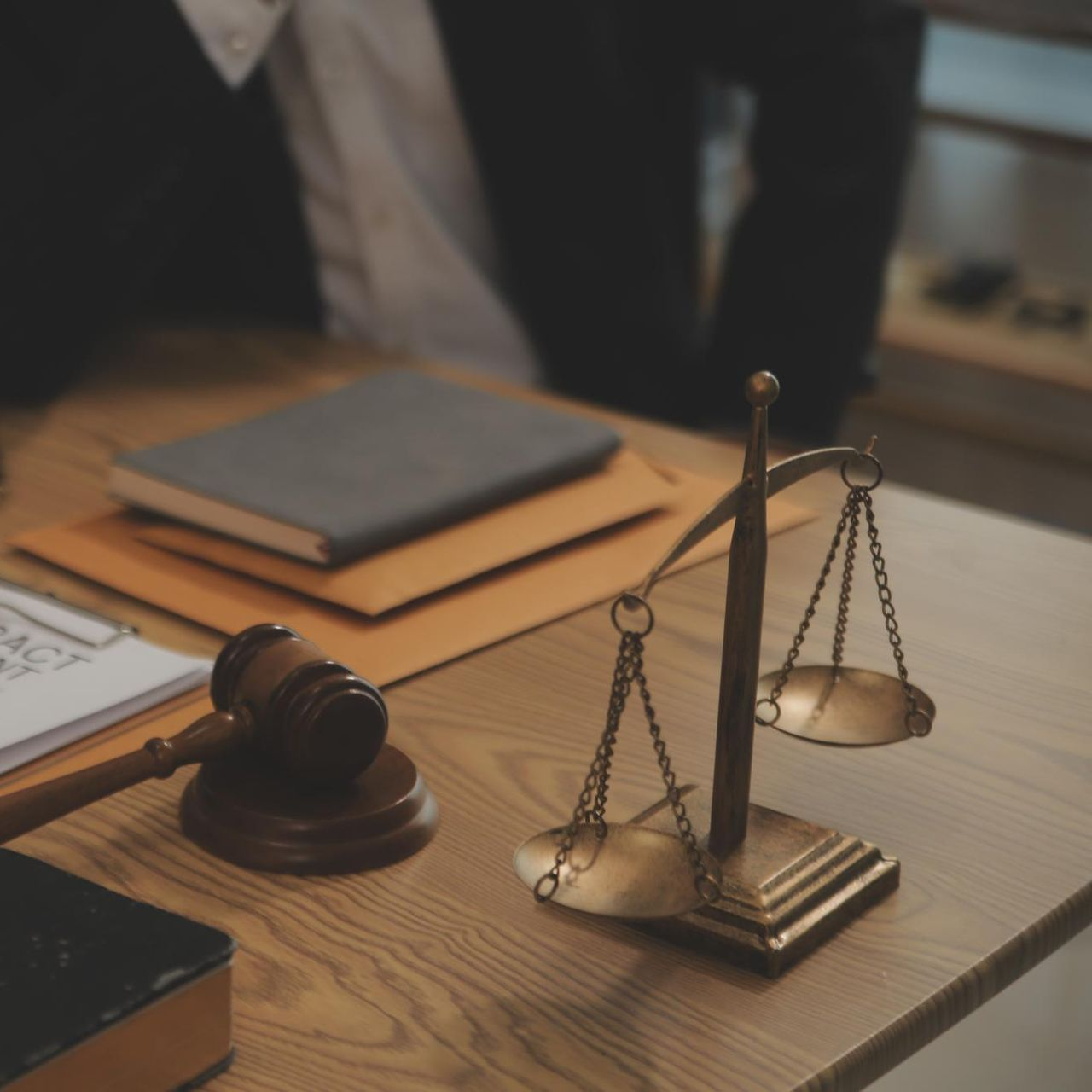 Lawyer’s desk with gavel, scales of justice, and stacked files on a wooden table