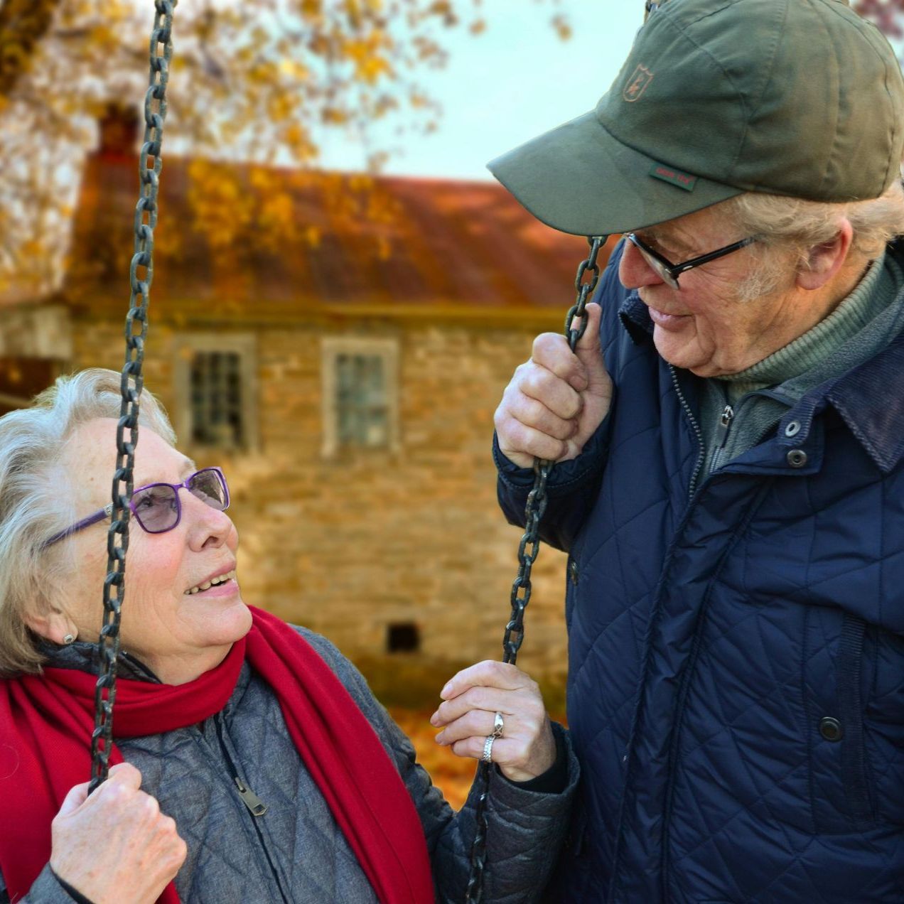 A man and a woman are playing on a swing