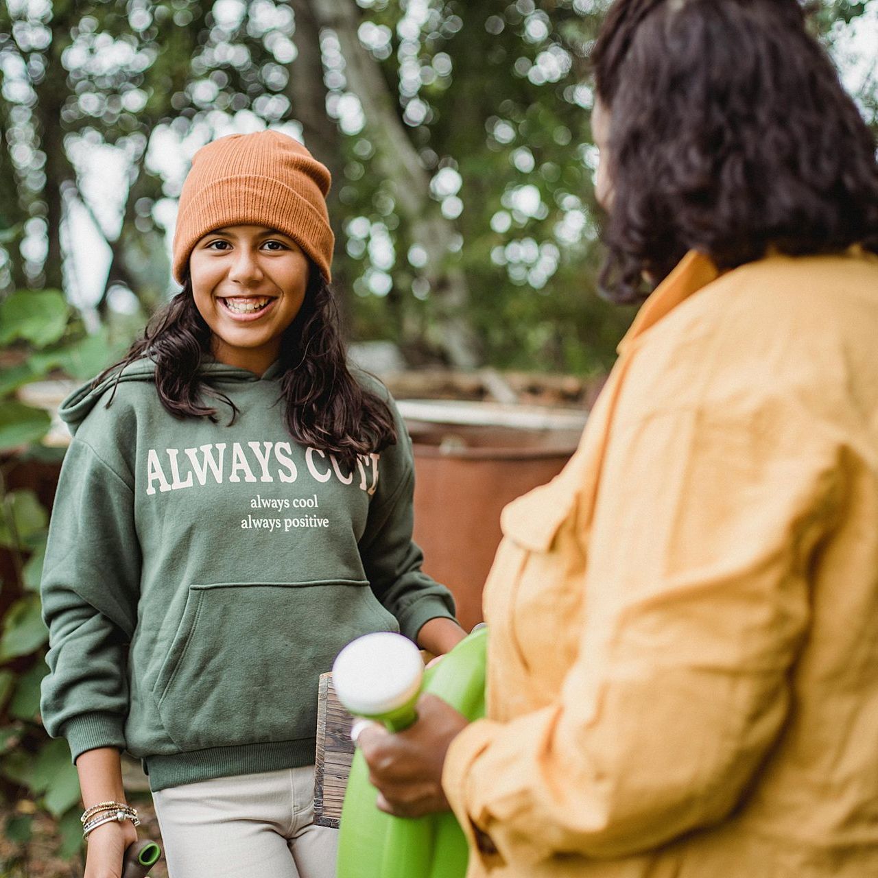 A woman wearing a green sweatshirt that says always on it