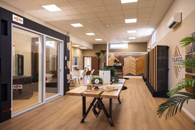 Interni di ufficio moderni con sale riunioni con pareti in vetro, scrivanie, pavimenti in legno e piante.