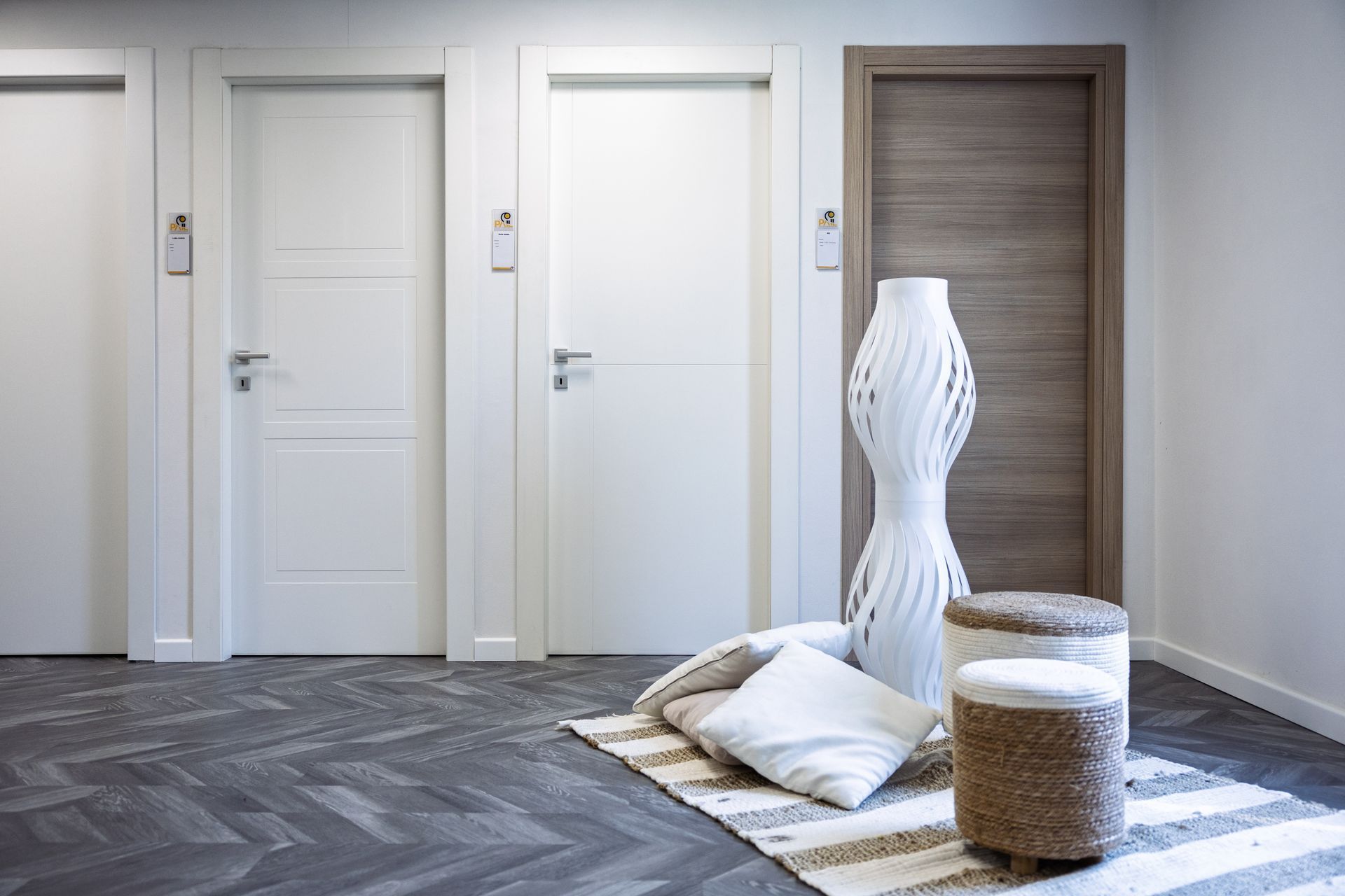 Ingresso moderno con porta in legno scuro, armadi a muro e pavimento in legno chiaro.