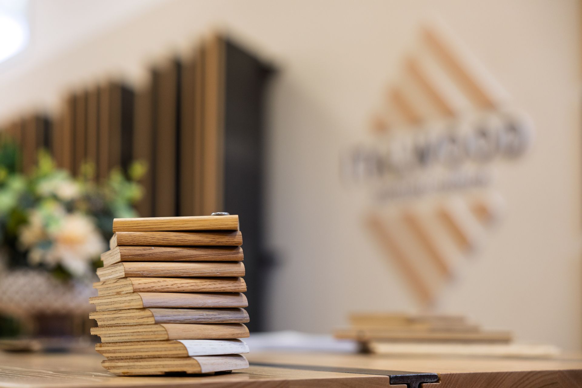 Una pila di piccoli campioni di legno su un tavolo in uno showroom