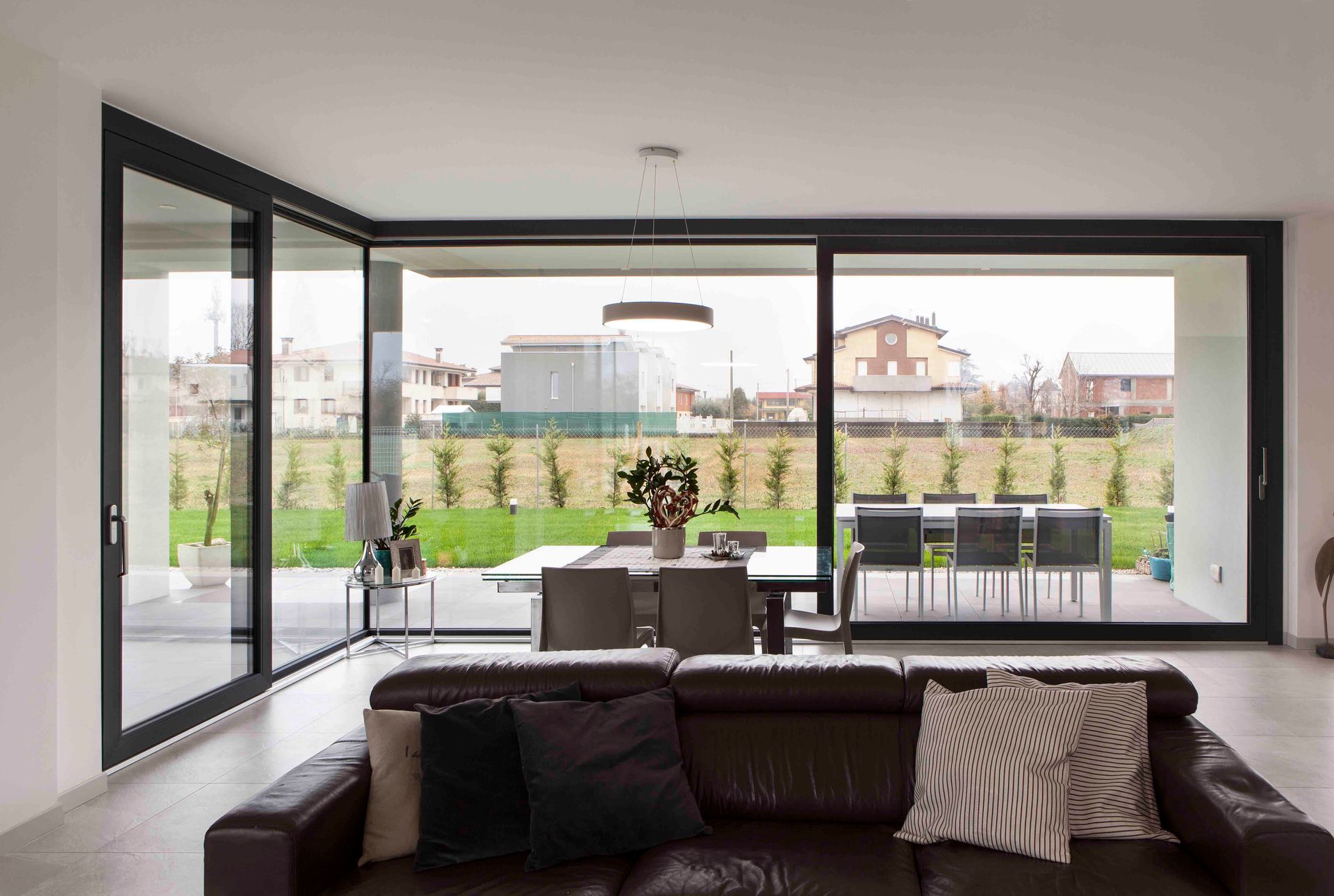 Soggiorno moderno con porte finestre che si aprono su un patio e un giardino.