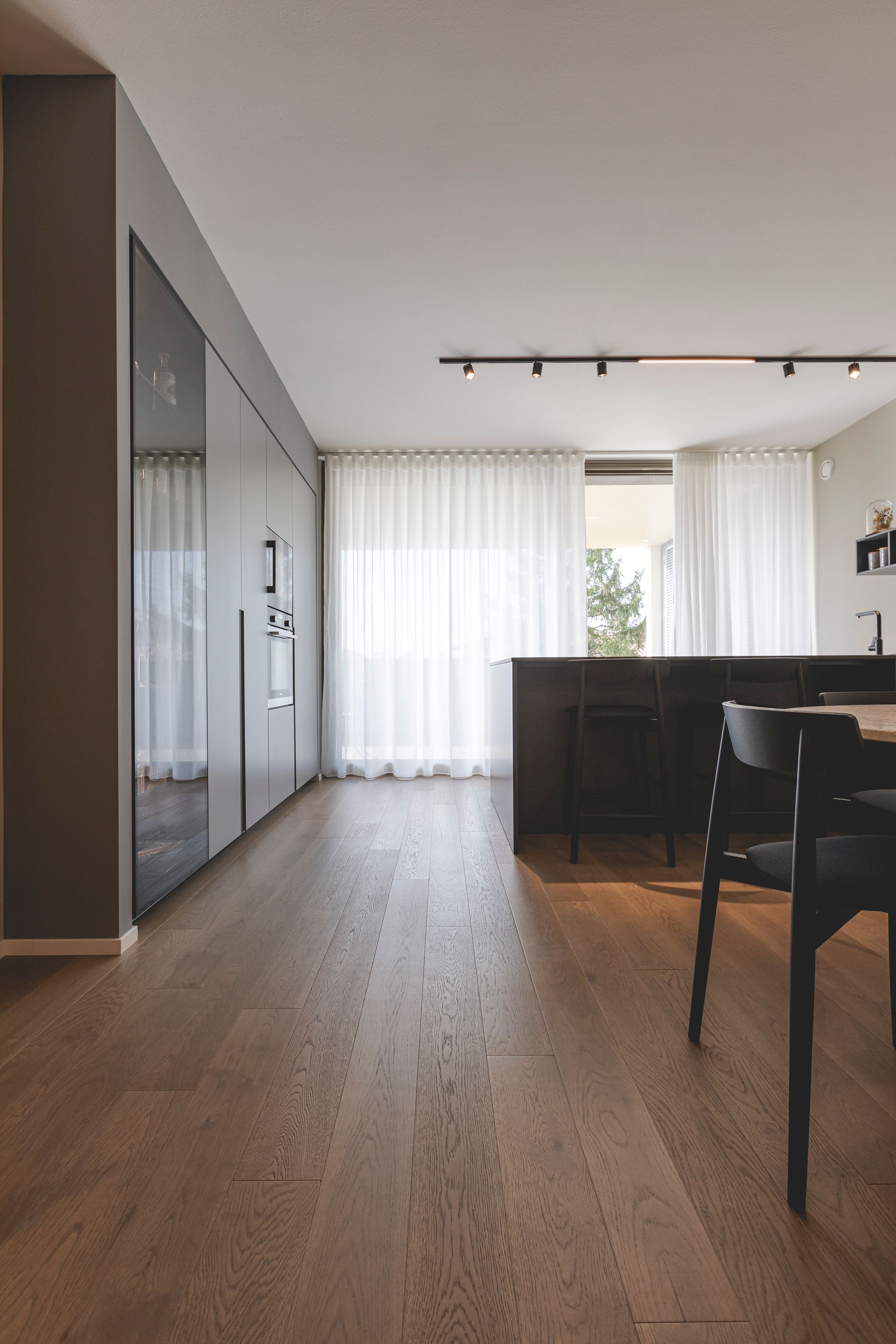 Cucina e zona pranzo moderne a pianta aperta con pavimento in legno