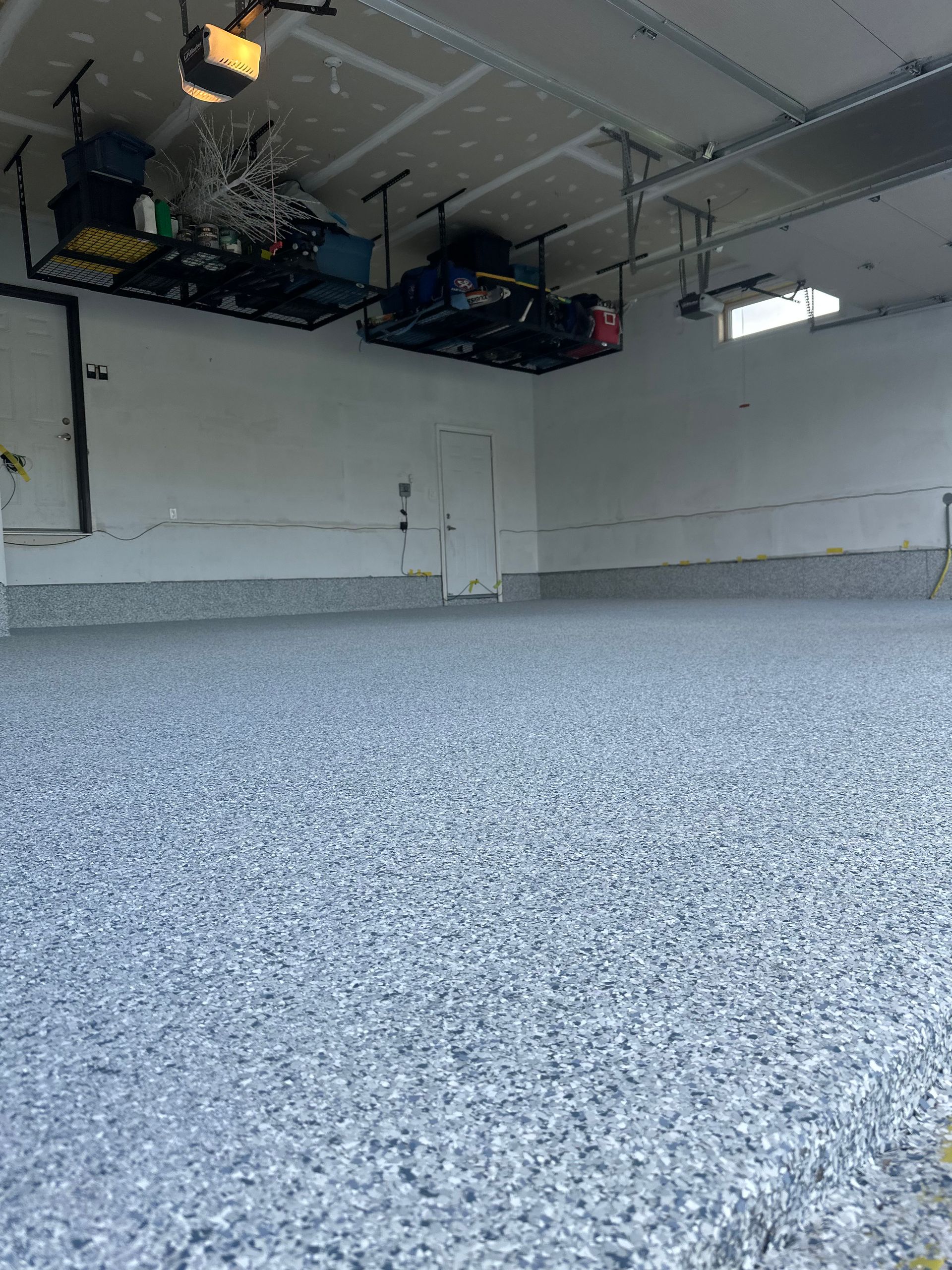 A garage with a gray floor and white walls.
