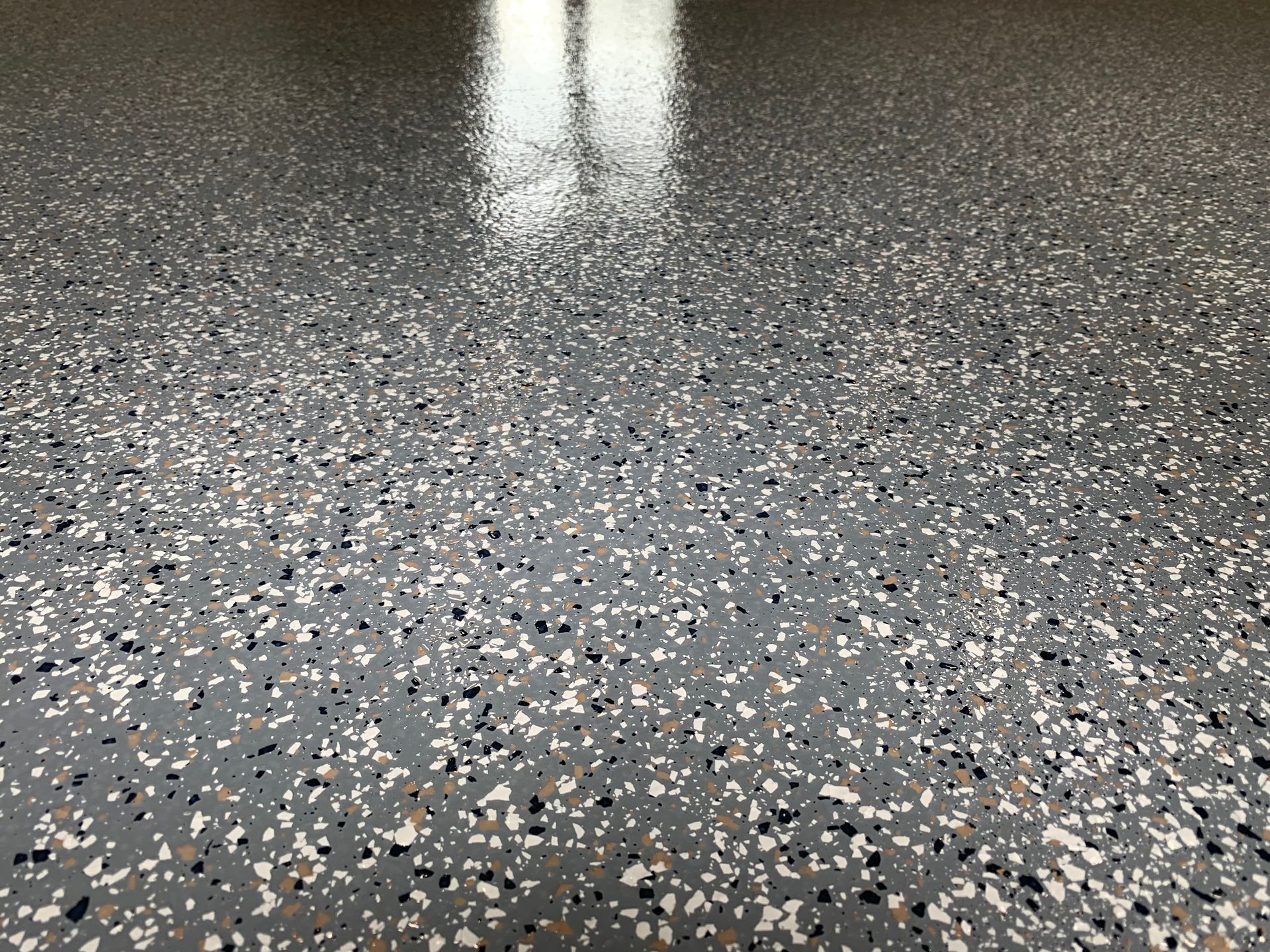 A close up of a garage floor with a lot of small stones on it.