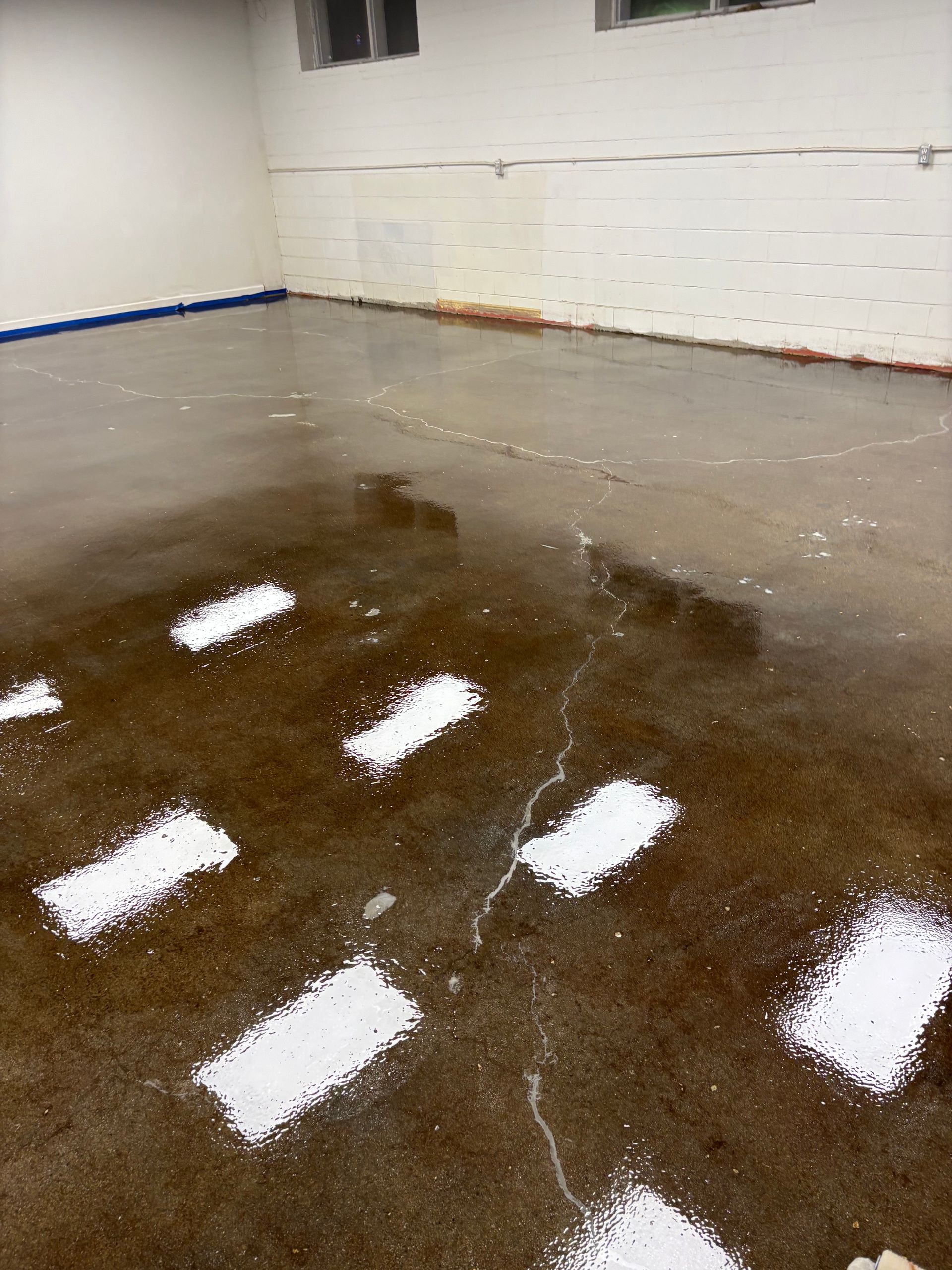 A room with a concrete floor and white markings on it.