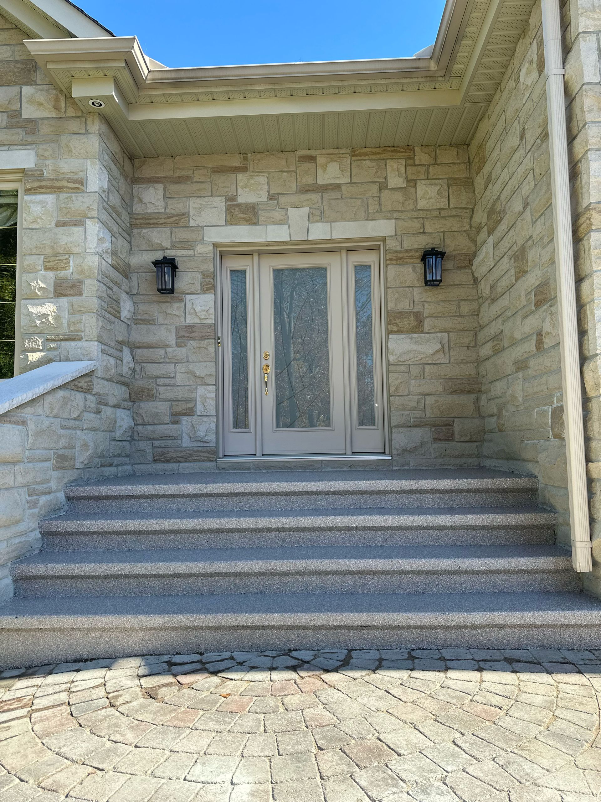 Stone house entrance with steps, double front door, and lantern lights