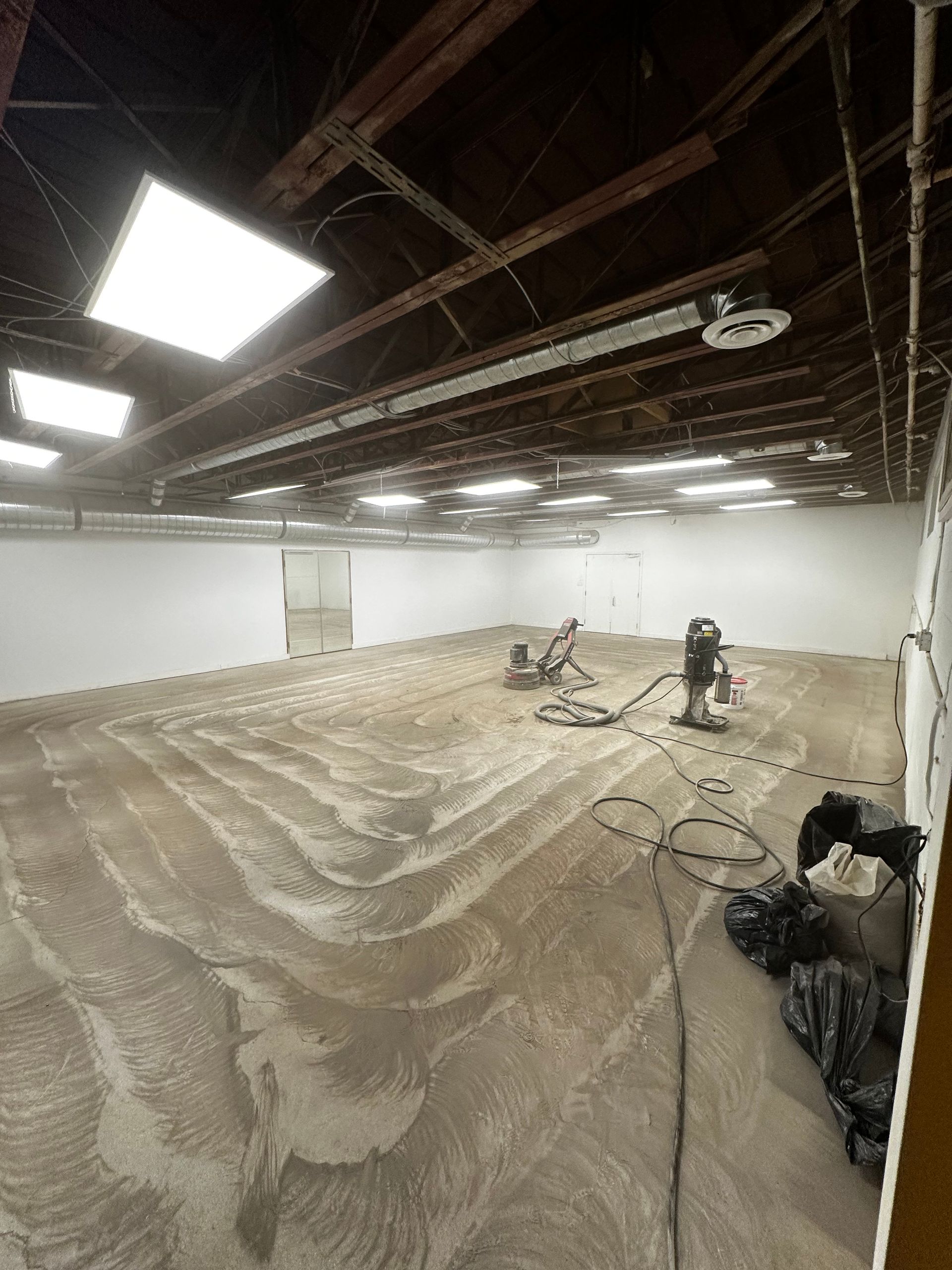 A large empty room with a vacuum cleaner on the floor.