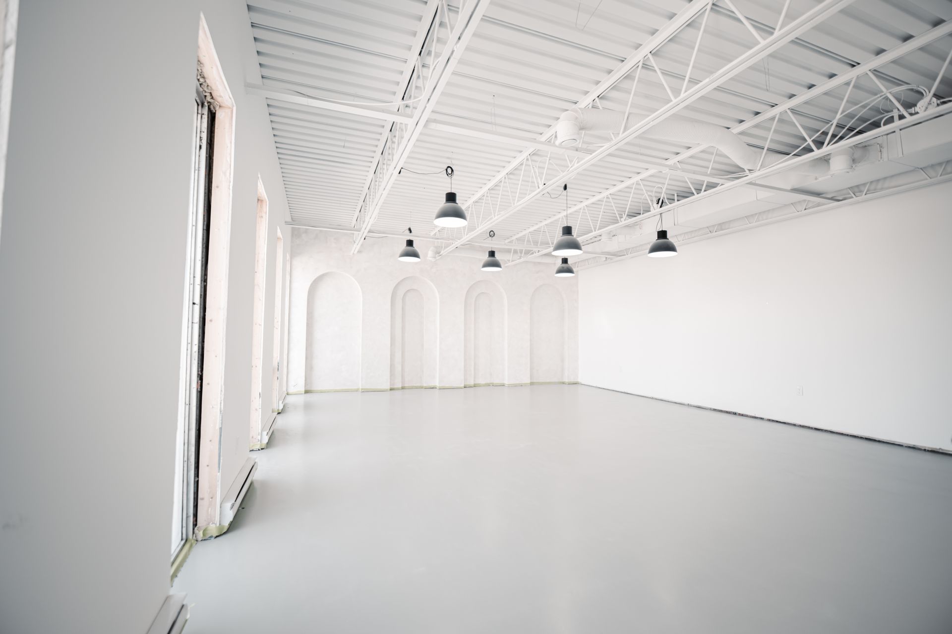 A large empty room with white walls and a white floor.
