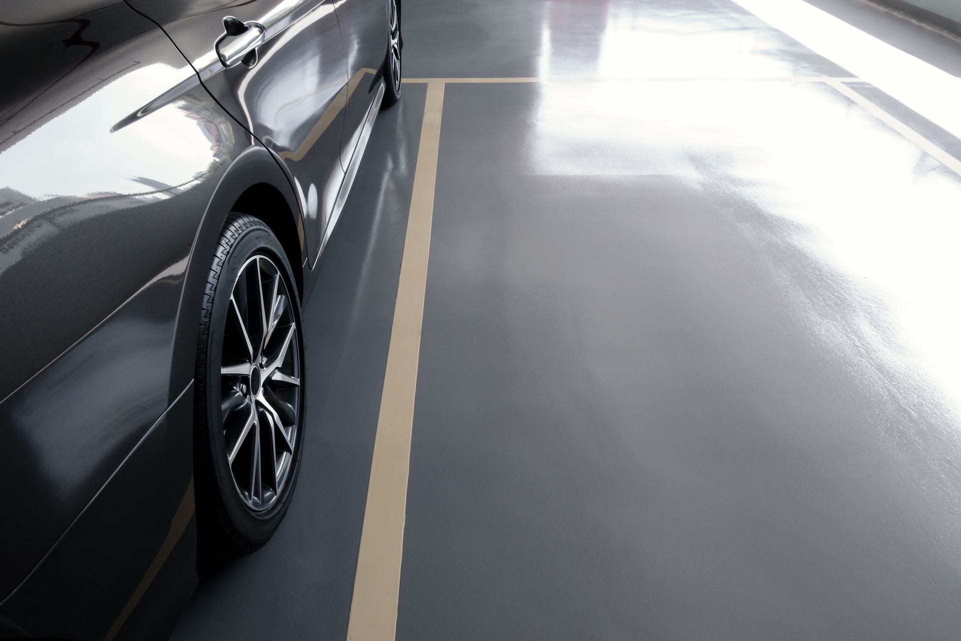 A black car is parked in a parking lot.