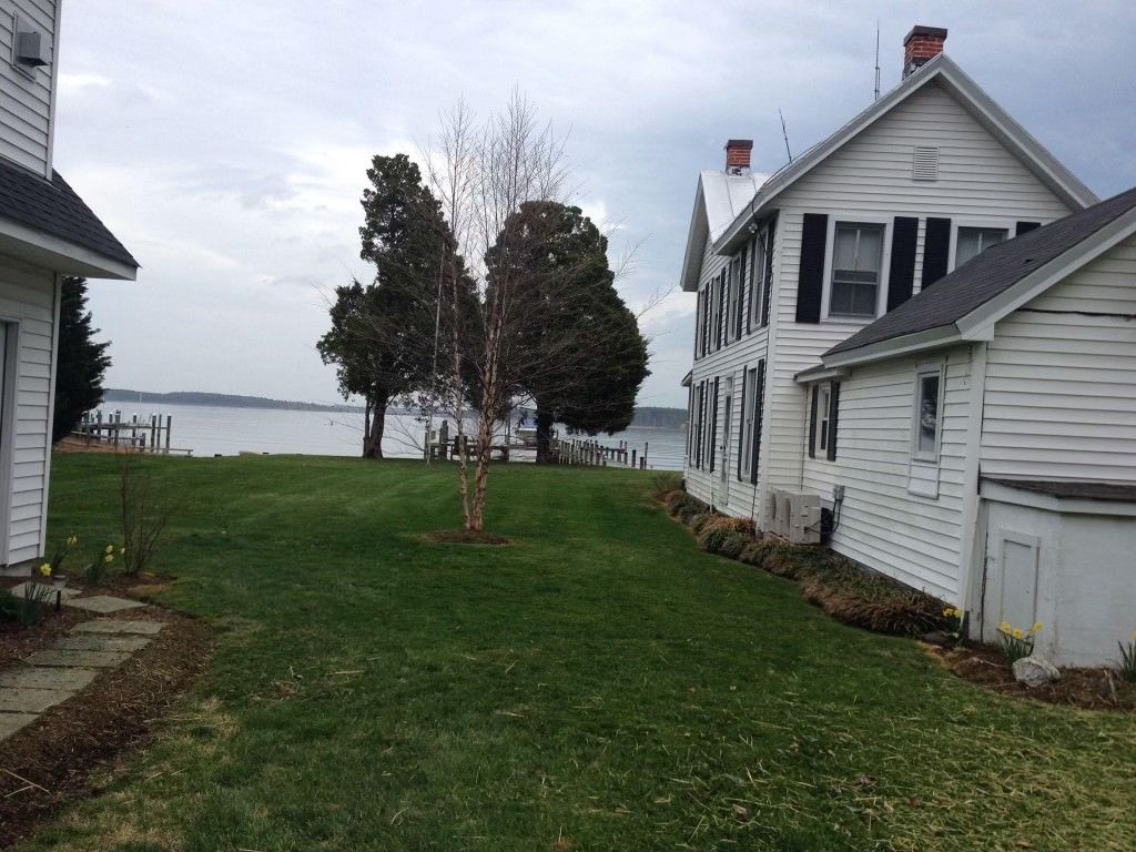 A large white house sits next to a smaller white house
