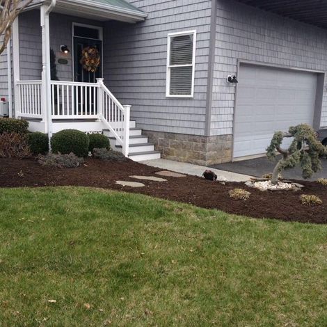 A gray house with a white porch and stairs